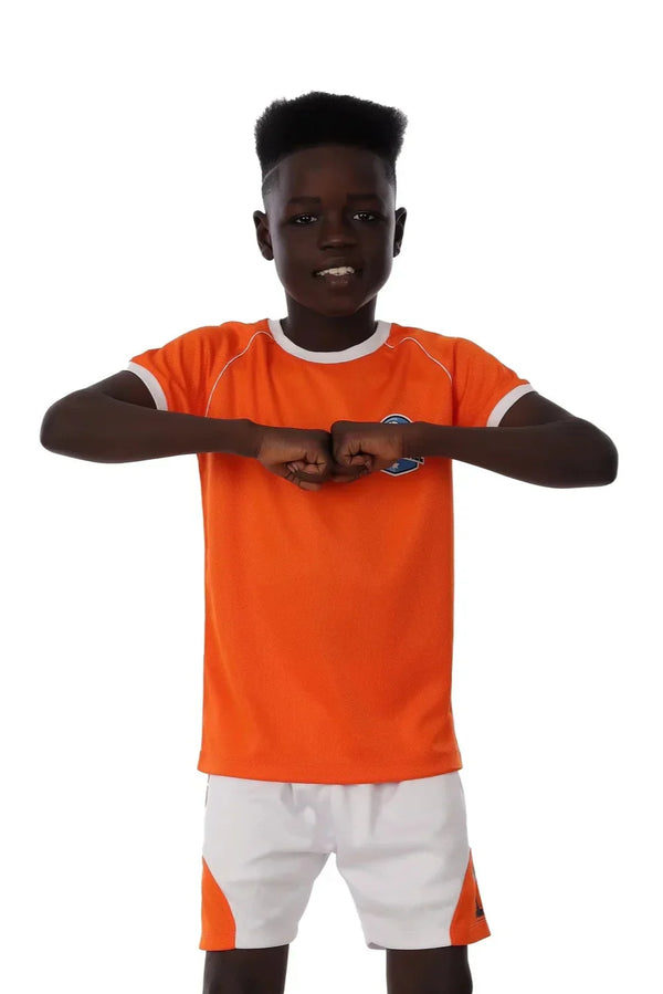 Person wearing an orange sports jersey and white shorts on a white background