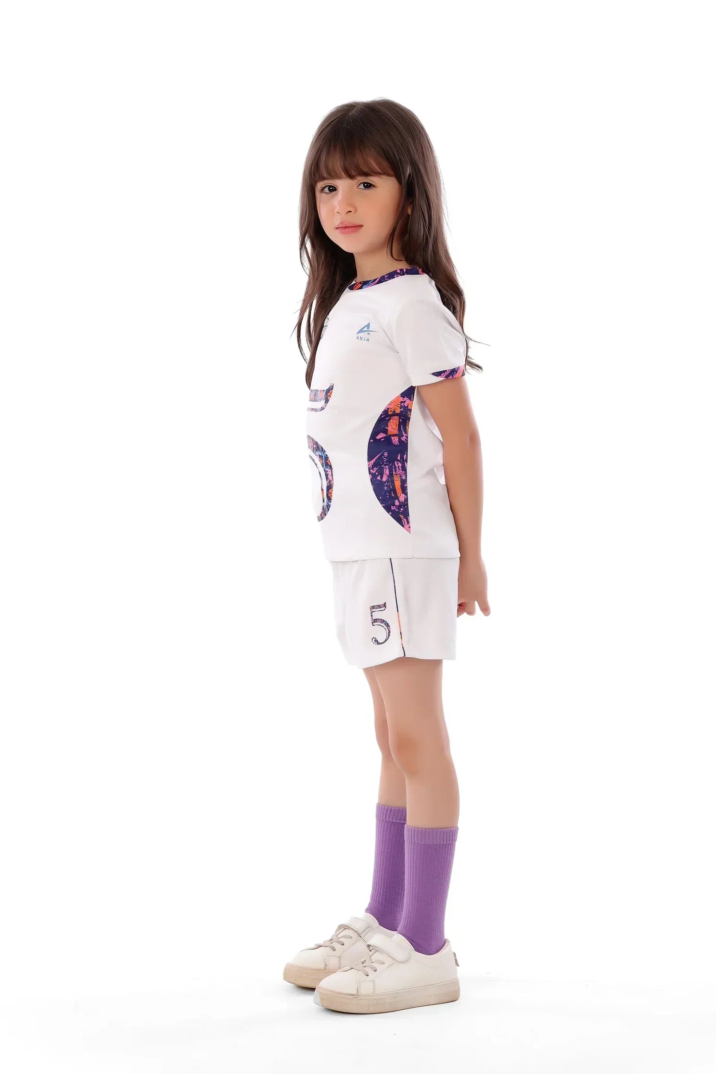 Young girl wearing a white sports outfit with colorful designs on a white background