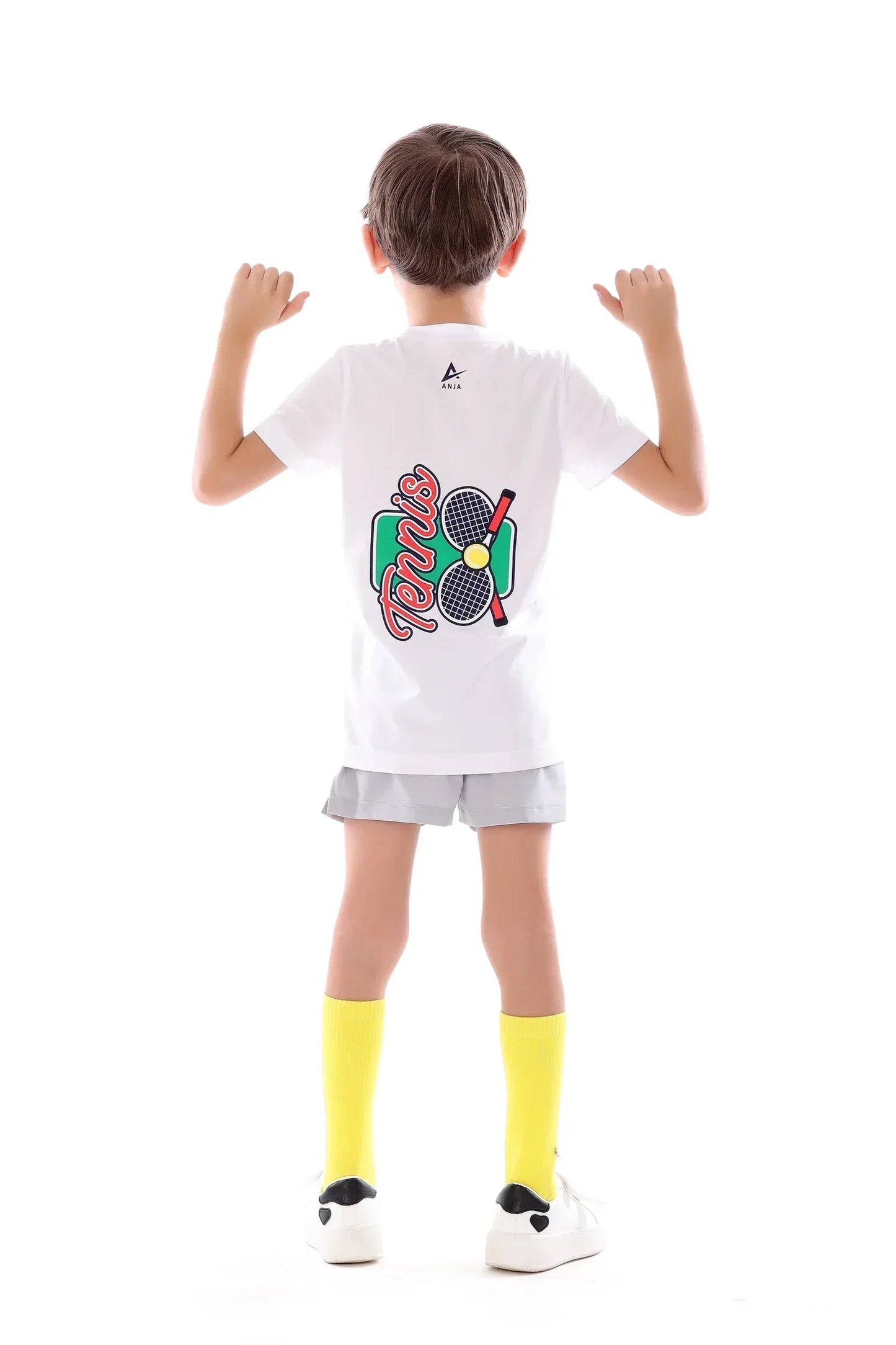 Child wearing a white t-shirt with colorful graphics on the back, standing against a white background.