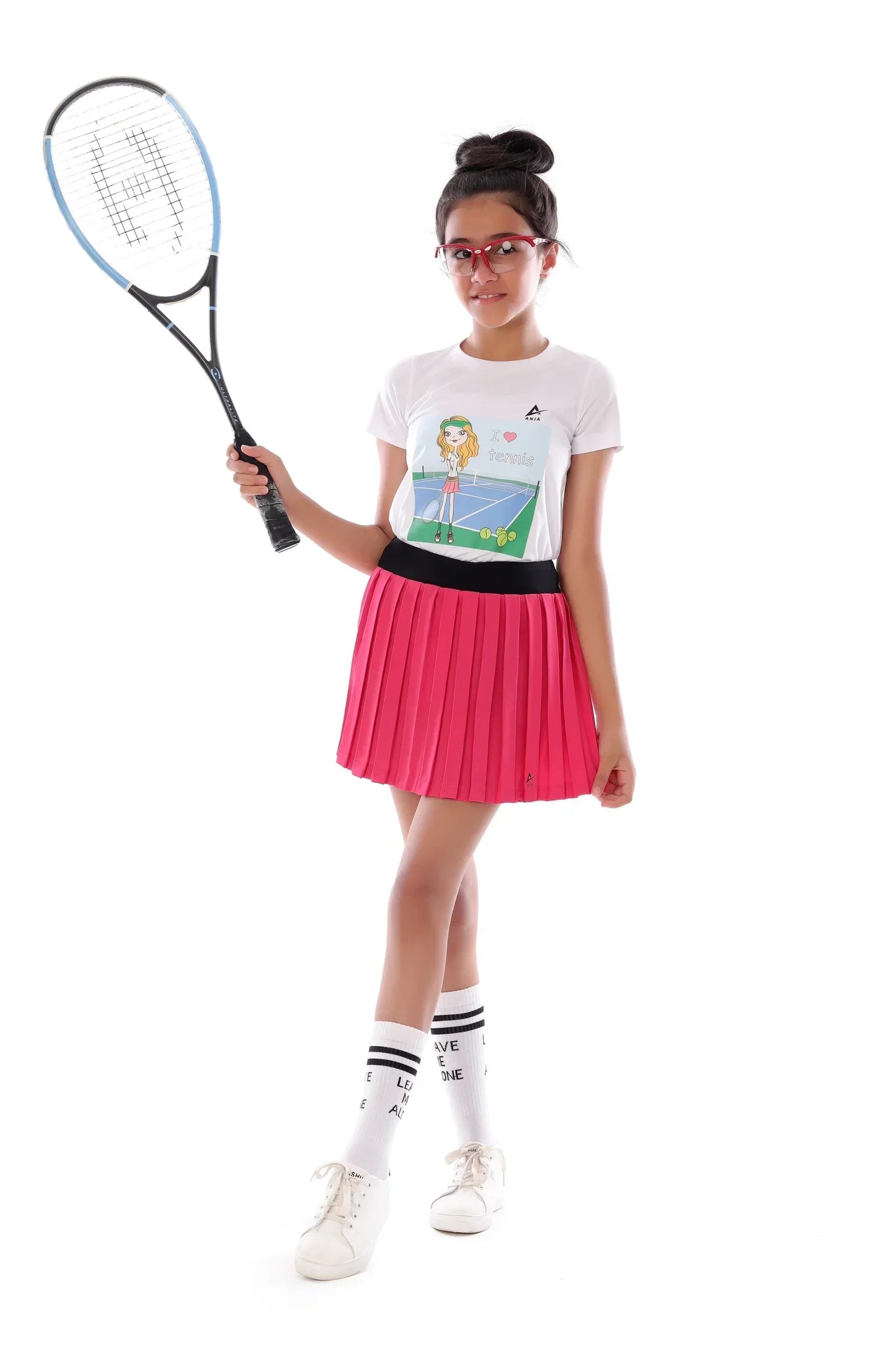 Girl holding a tennis racket wearing a white shirt with a design and a pink skirt on a white background