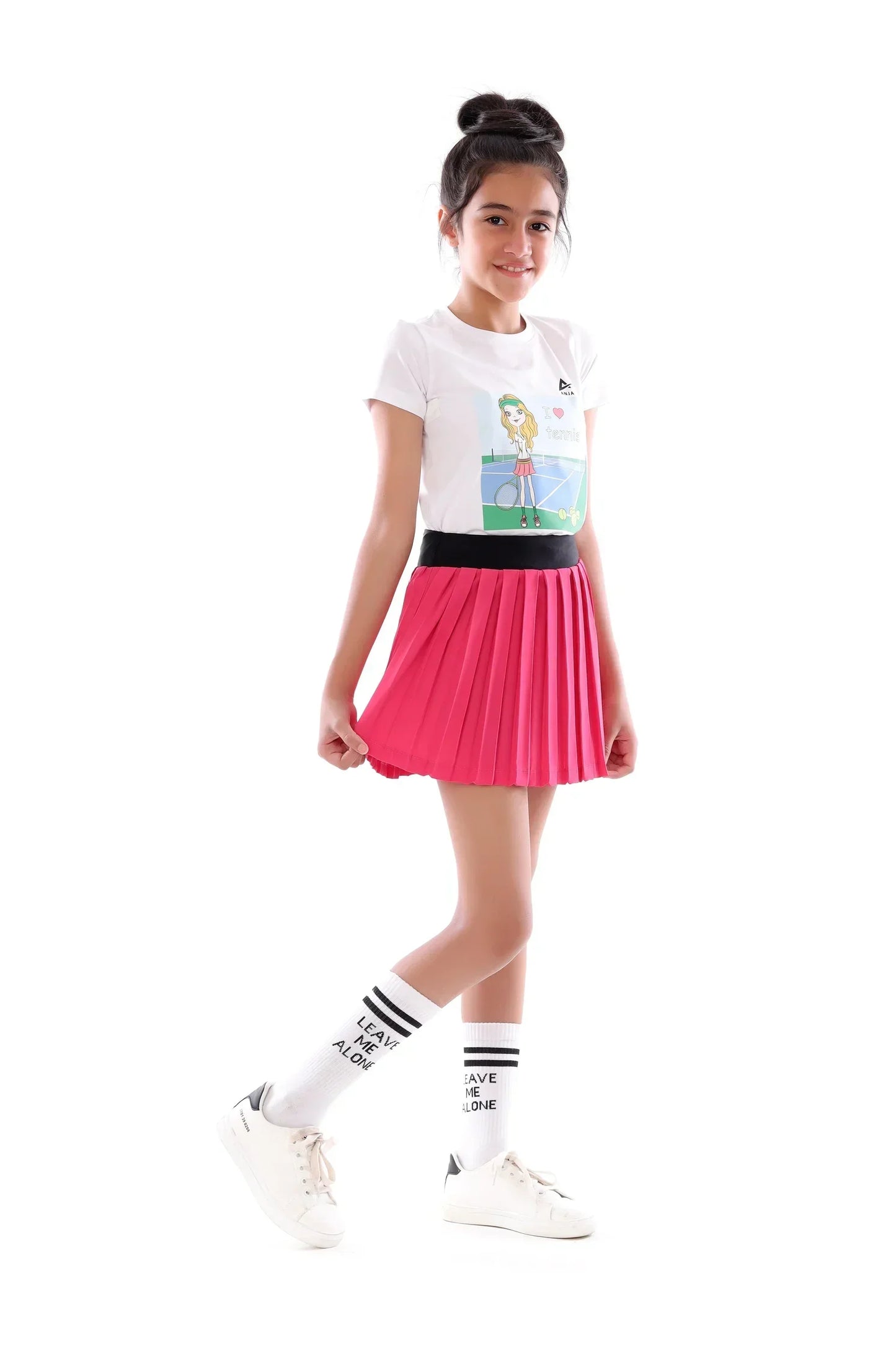 Young girl wearing a white t-shirt with a graphic design, pink skirt, and white socks with text on a white background