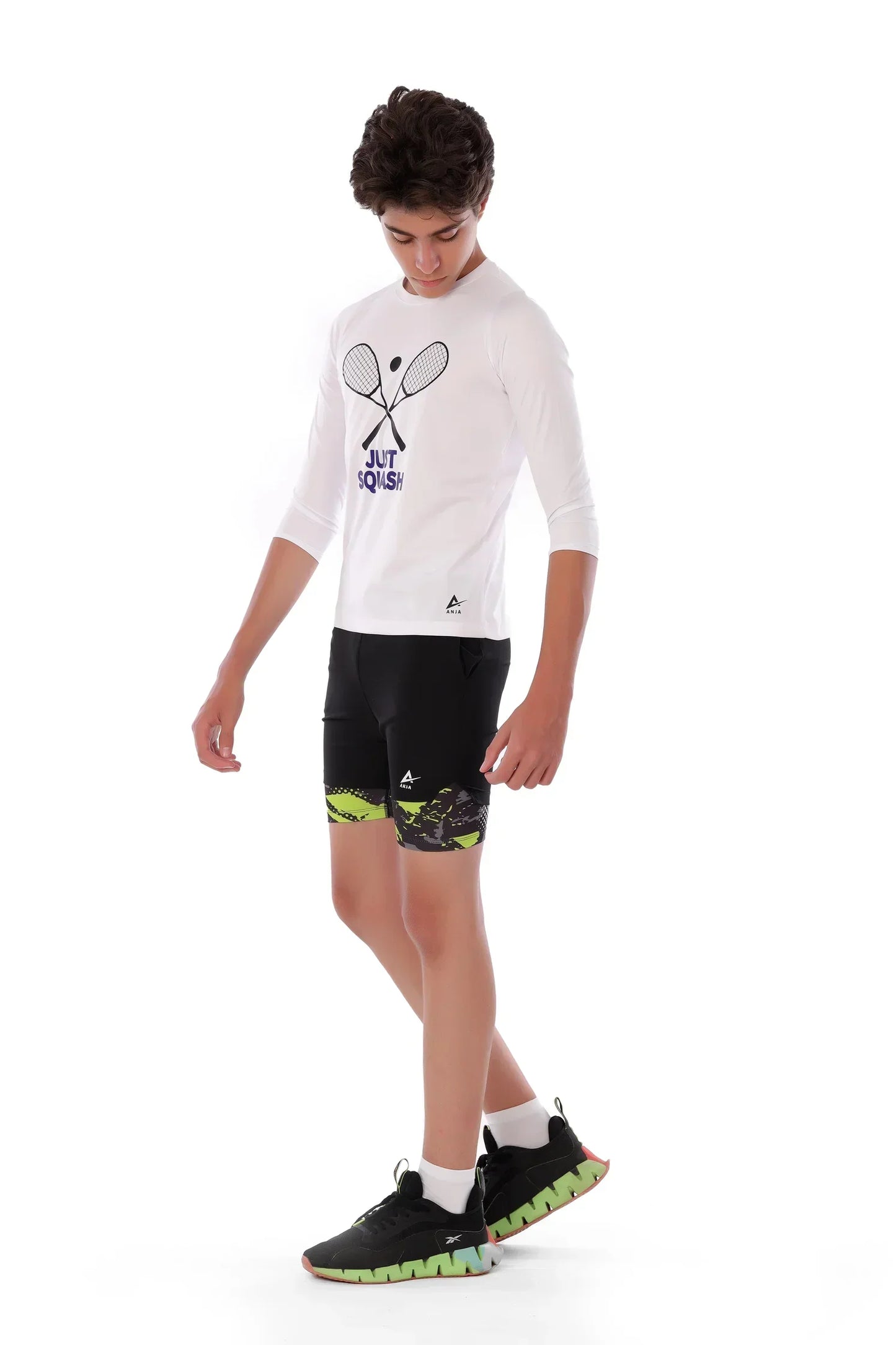 Person wearing a white long-sleeve shirt with a graphic design and black shorts on a white background