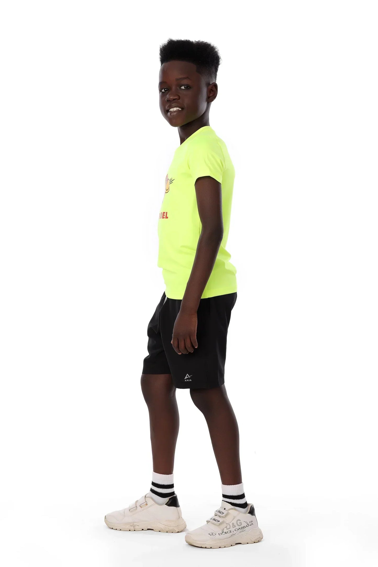 Person wearing a bright yellow t-shirt and black shorts on a white background