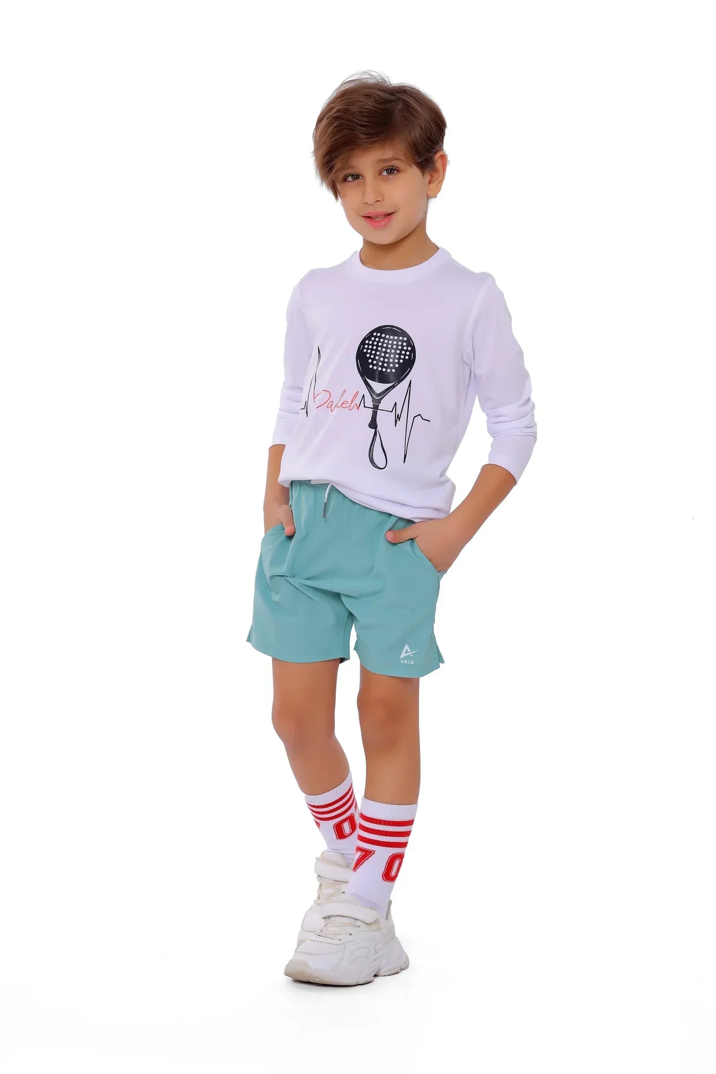 Child wearing a white long-sleeve shirt with a graphic design and light blue shorts on a white background