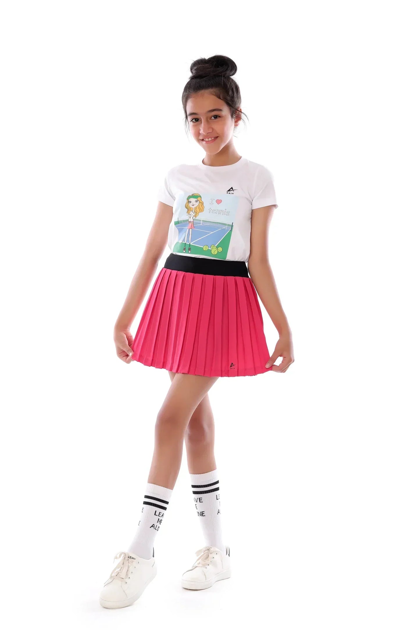 Person wearing a white t-shirt with a graphic design and a pink pleated skirt on a white background