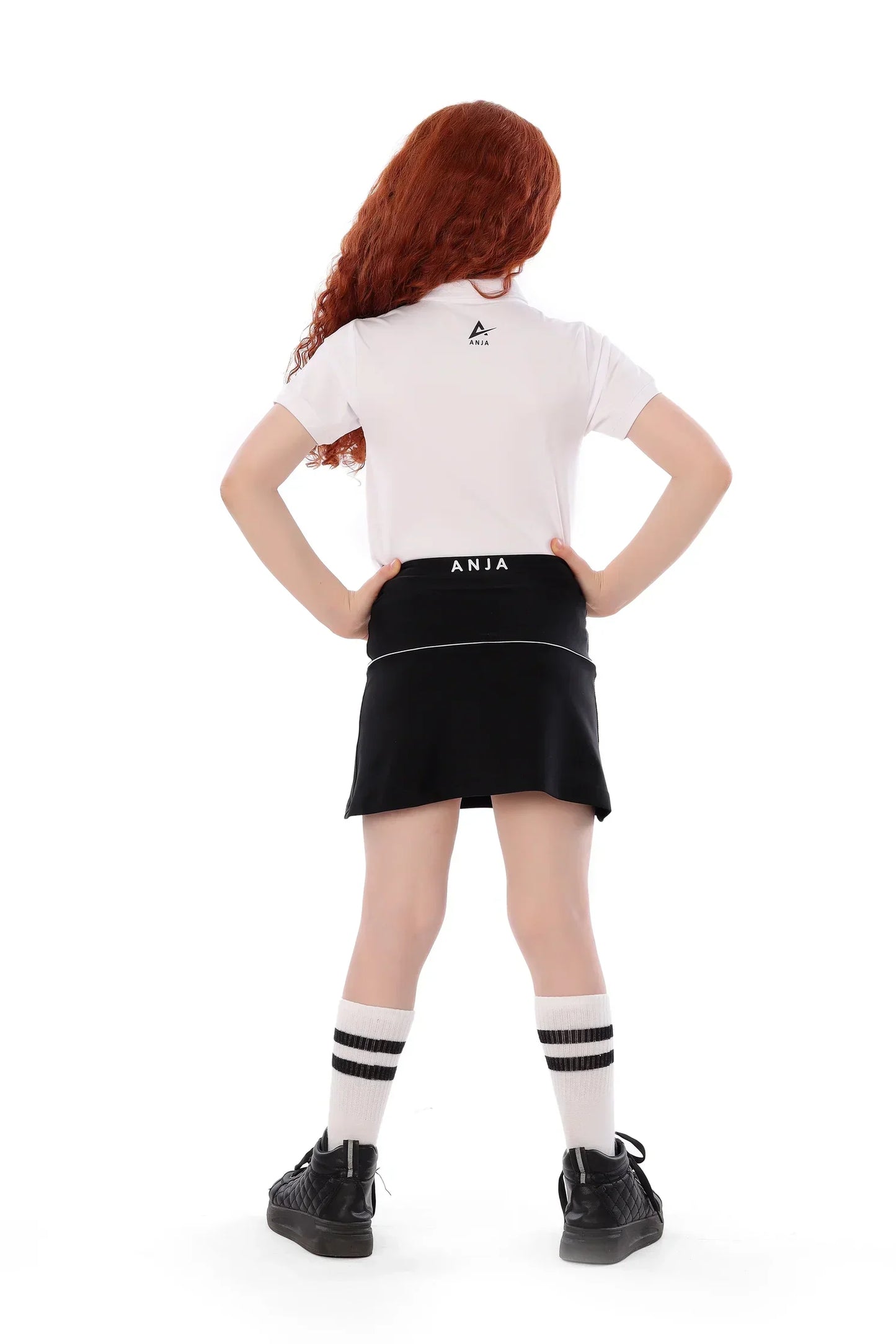 Person wearing a white polo shirt and black skirt with 'ANIA' branding on a white background