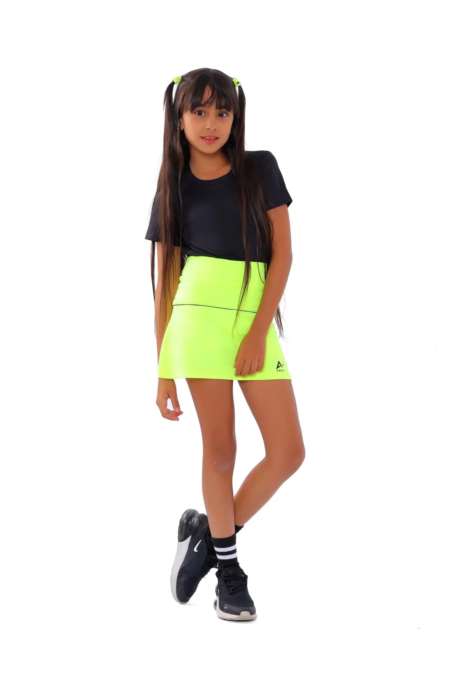 Person wearing a black t-shirt and bright green shorts on a white background