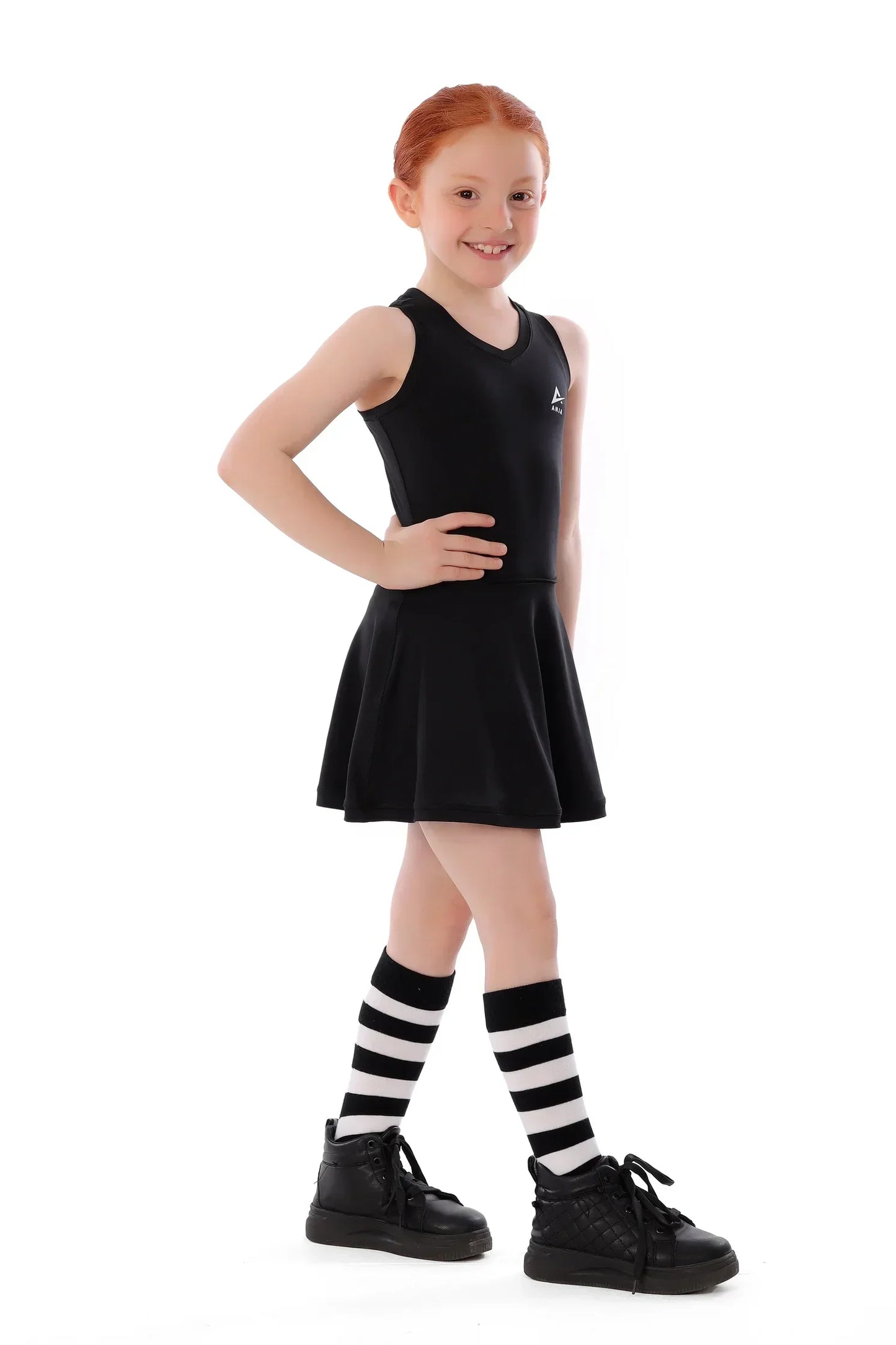Young girl wearing a black dress with striped socks on a white background