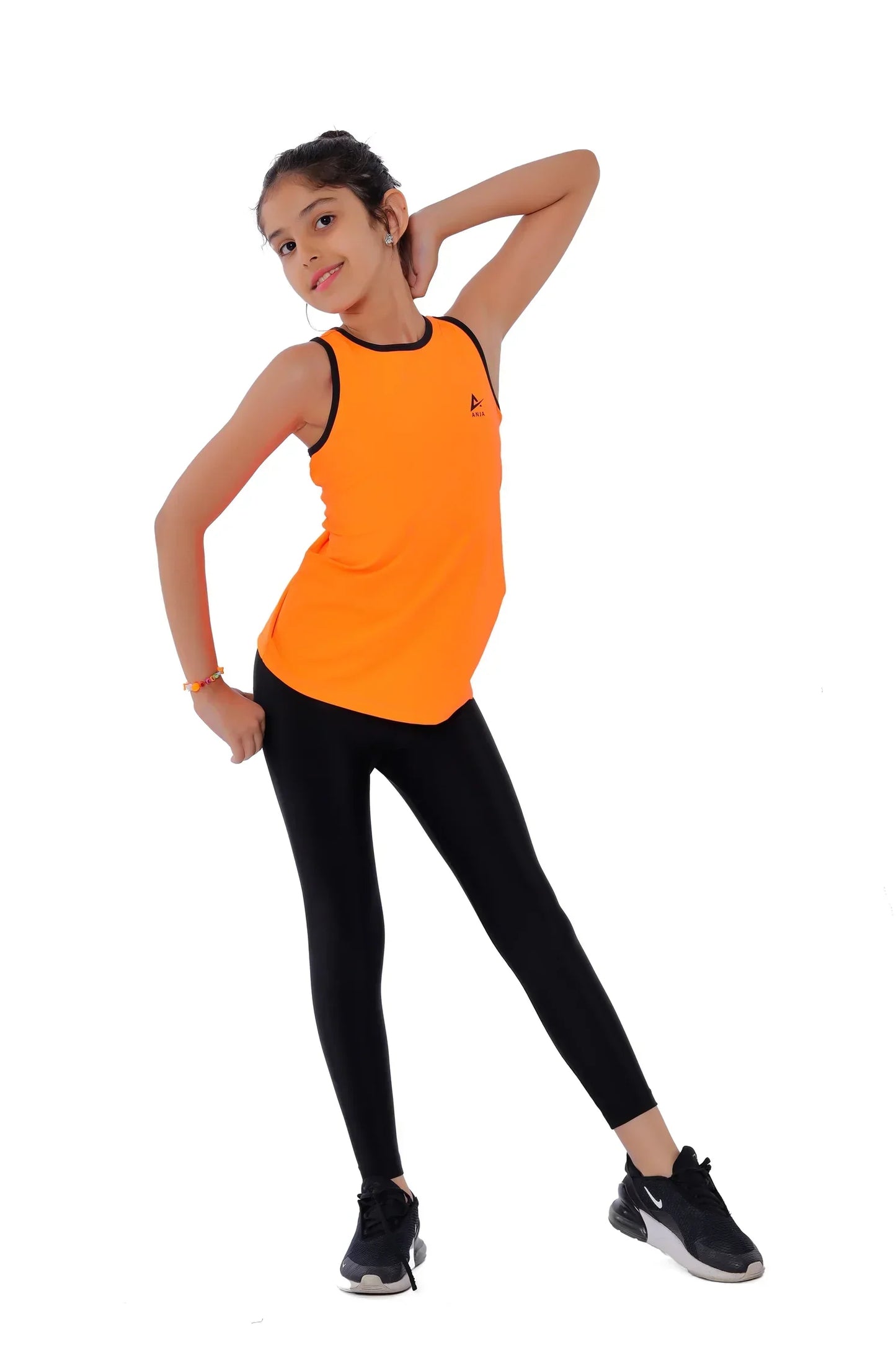 Person wearing an orange tank top and black leggings on a white background