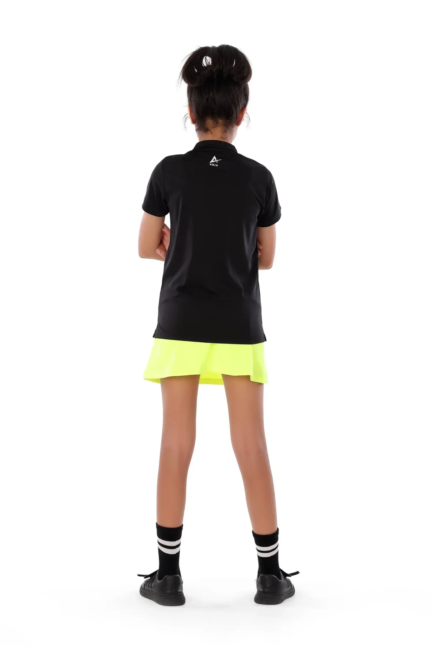 Person wearing a black polo shirt and yellow skirt on a white background