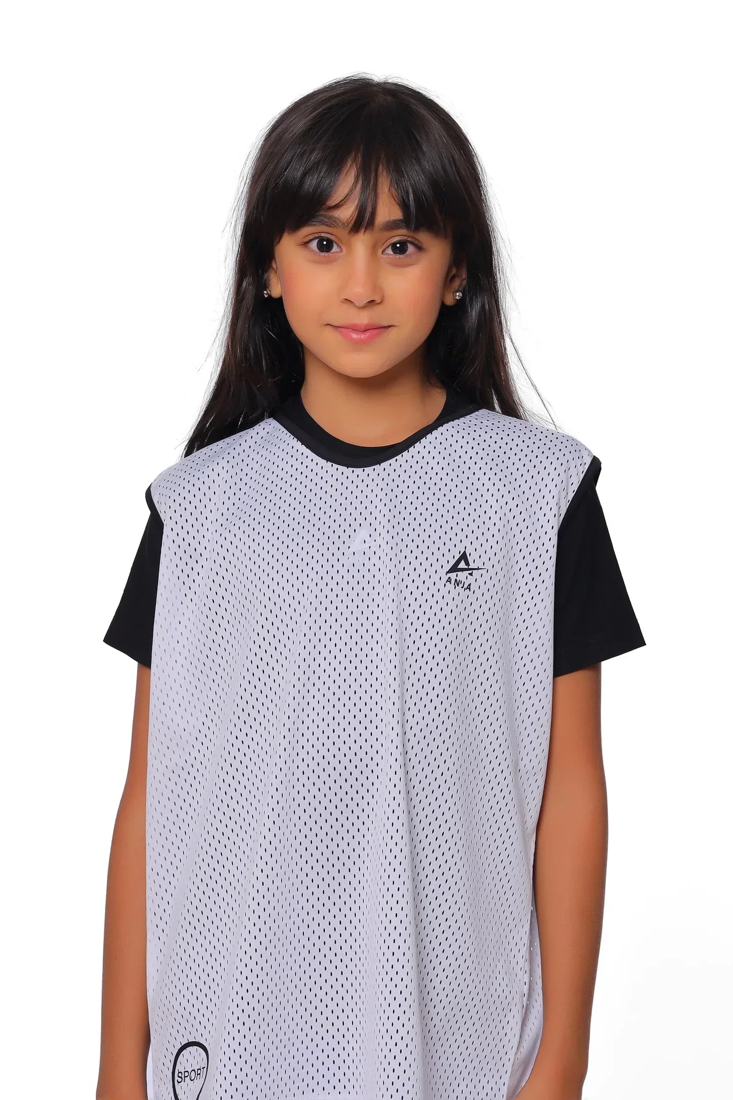 Young girl wearing a black and white sports jersey on a white background