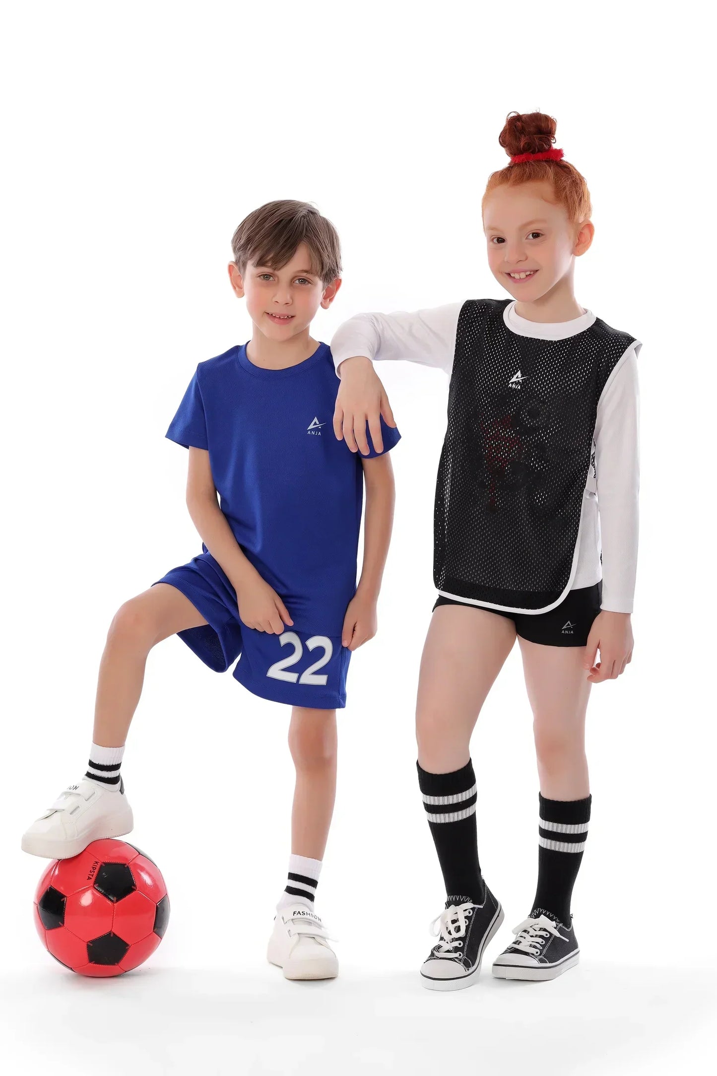 Two children in sports attire with a soccer ball on a white background