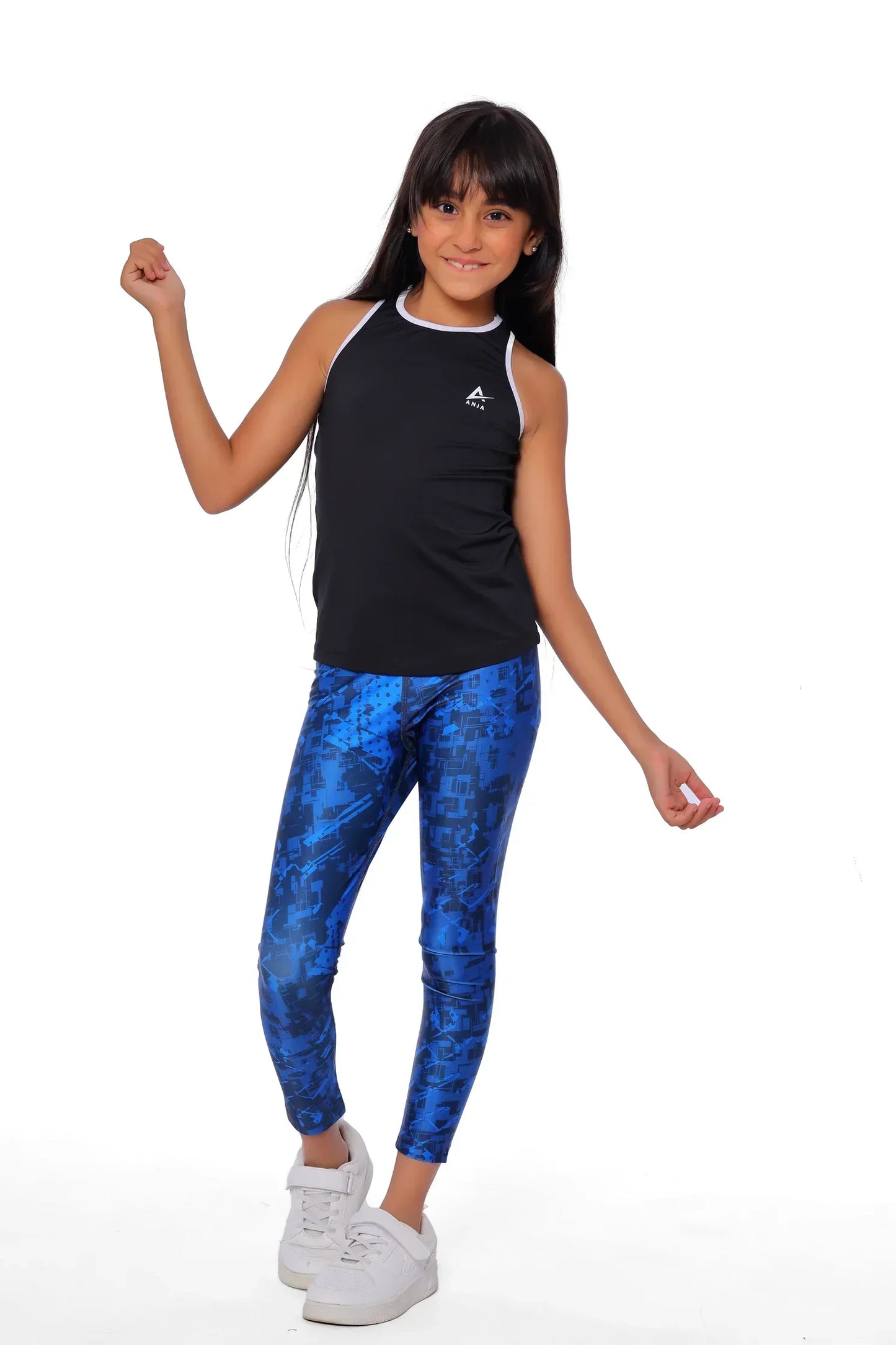 Girl wearing a black sleeveless top and blue patterned leggings on a white background