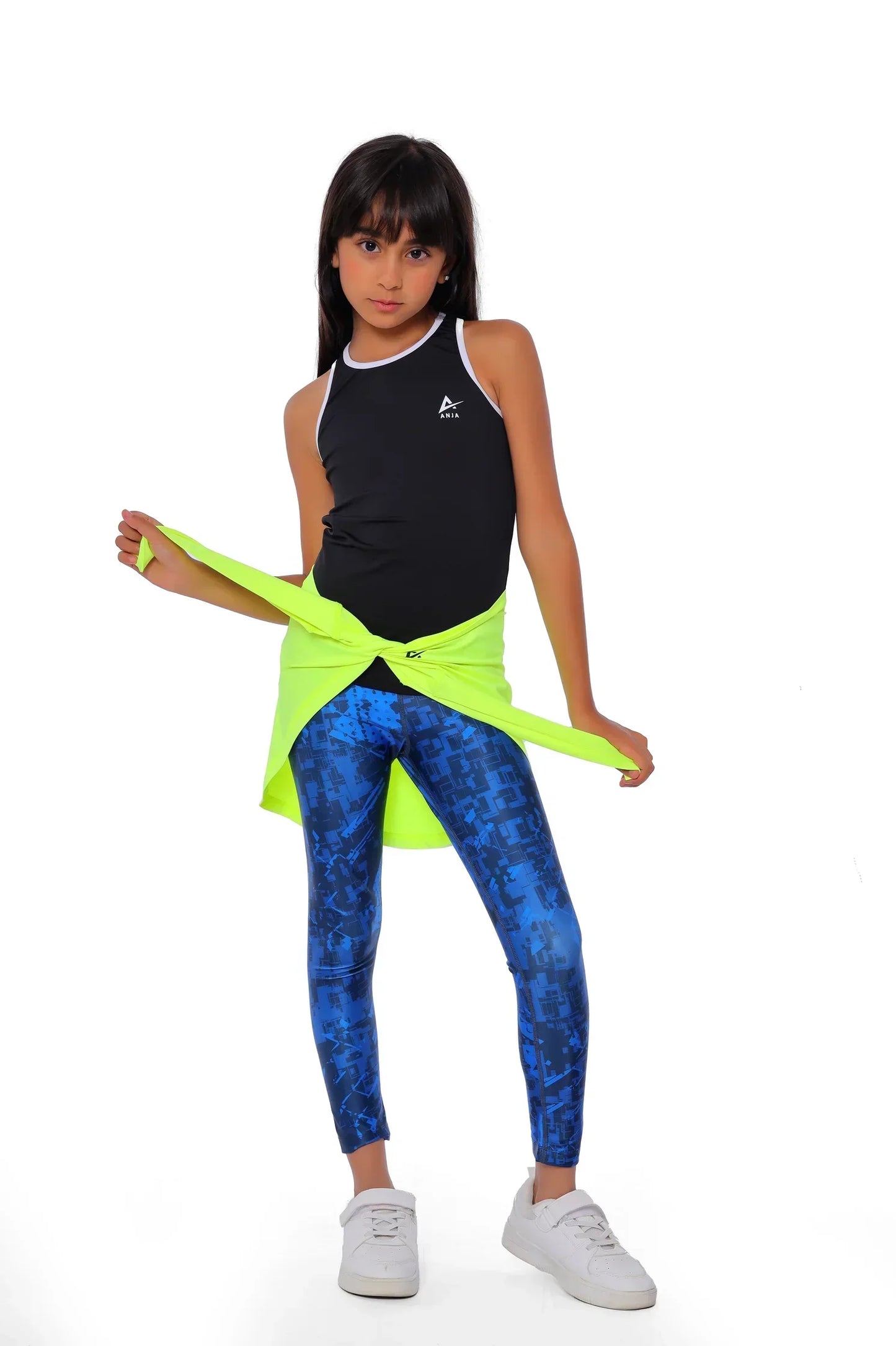 Person wearing a black tank top and blue leggings with a green resistance band on a white background