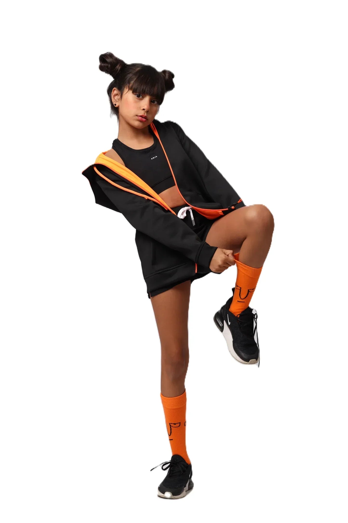 Person wearing a black and orange outfit with matching socks on a white background