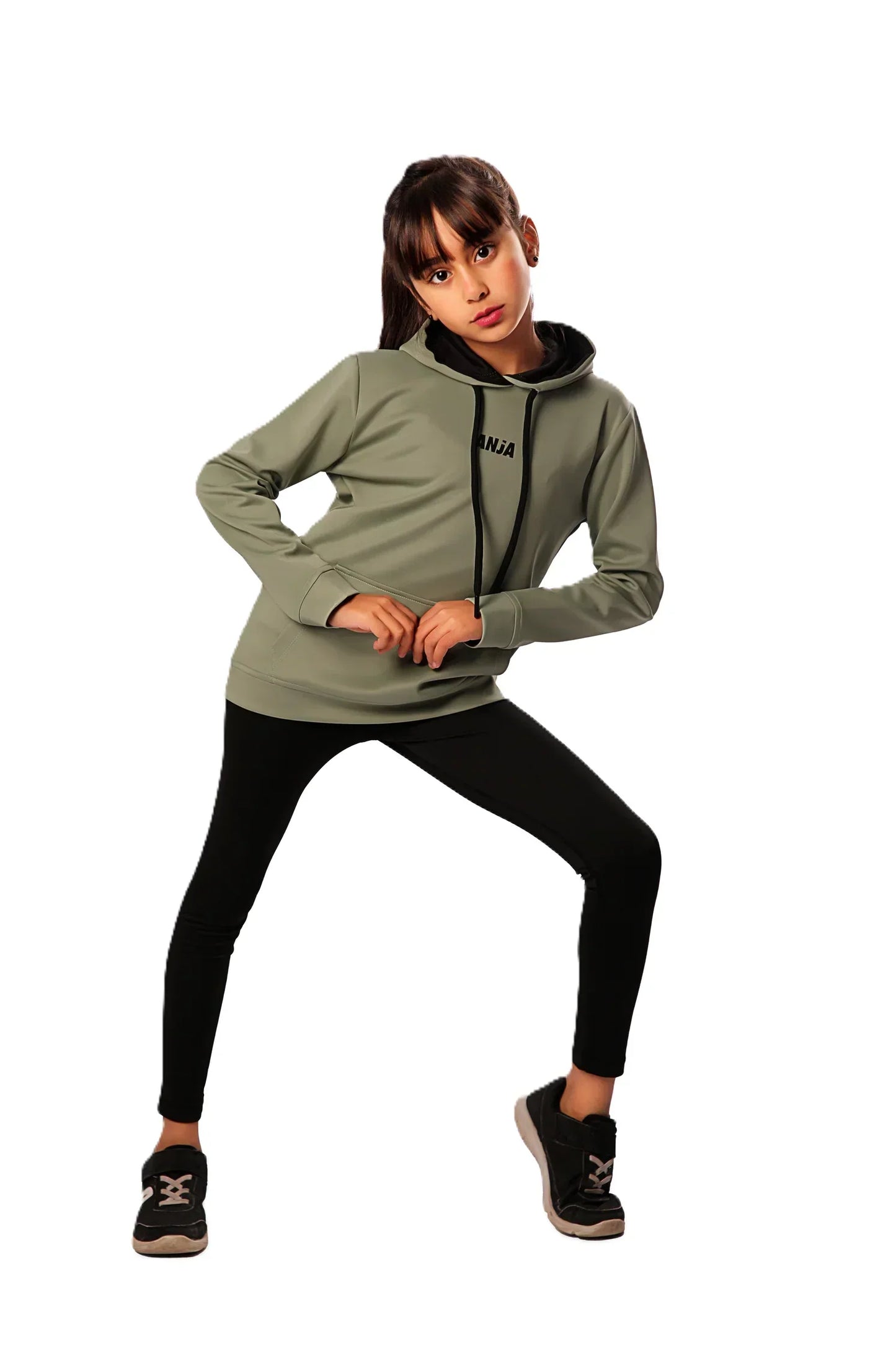 Person wearing a green hoodie and black leggings on a white background