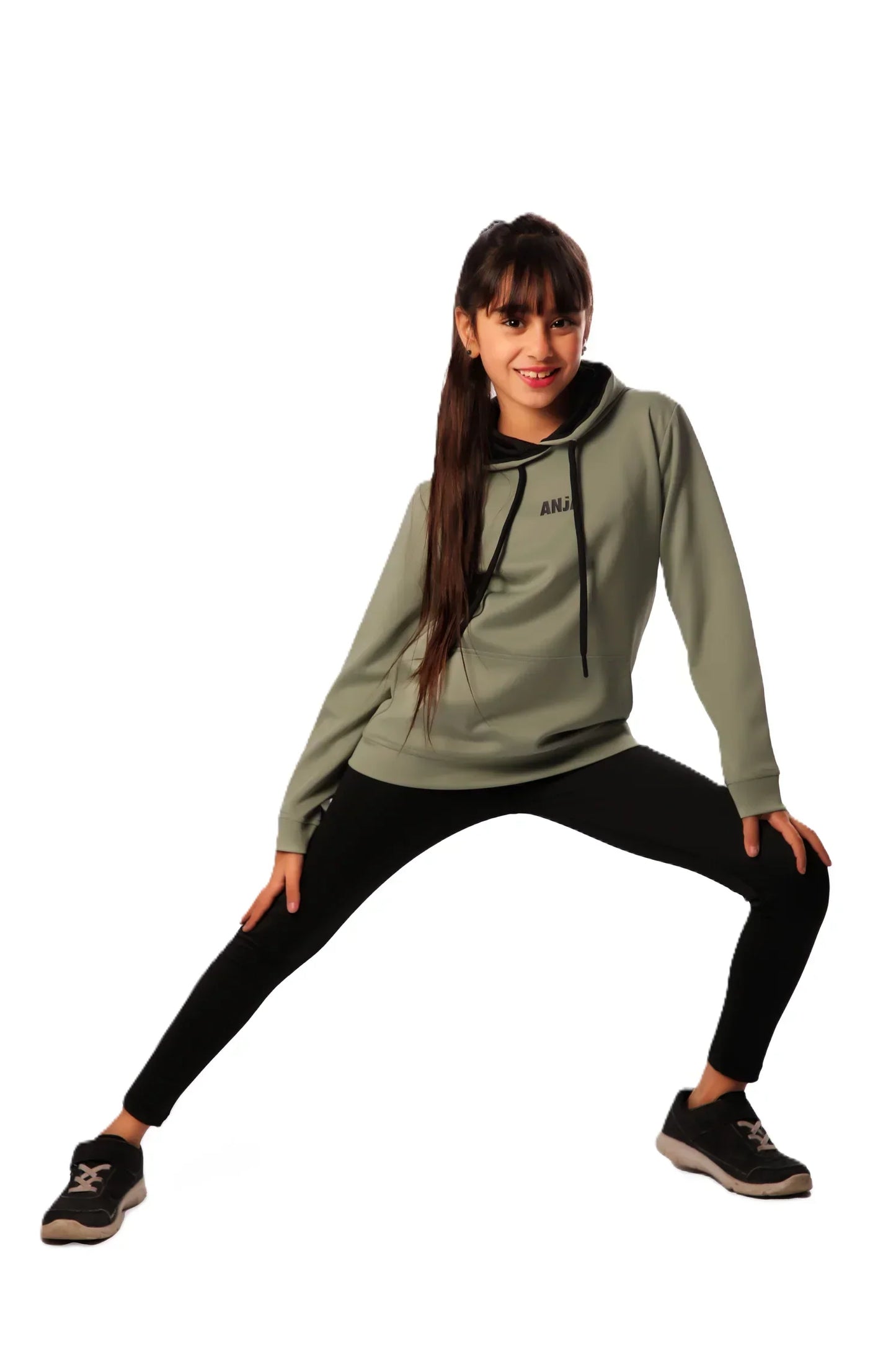 Woman wearing a green hoodie and black leggings on a white background
