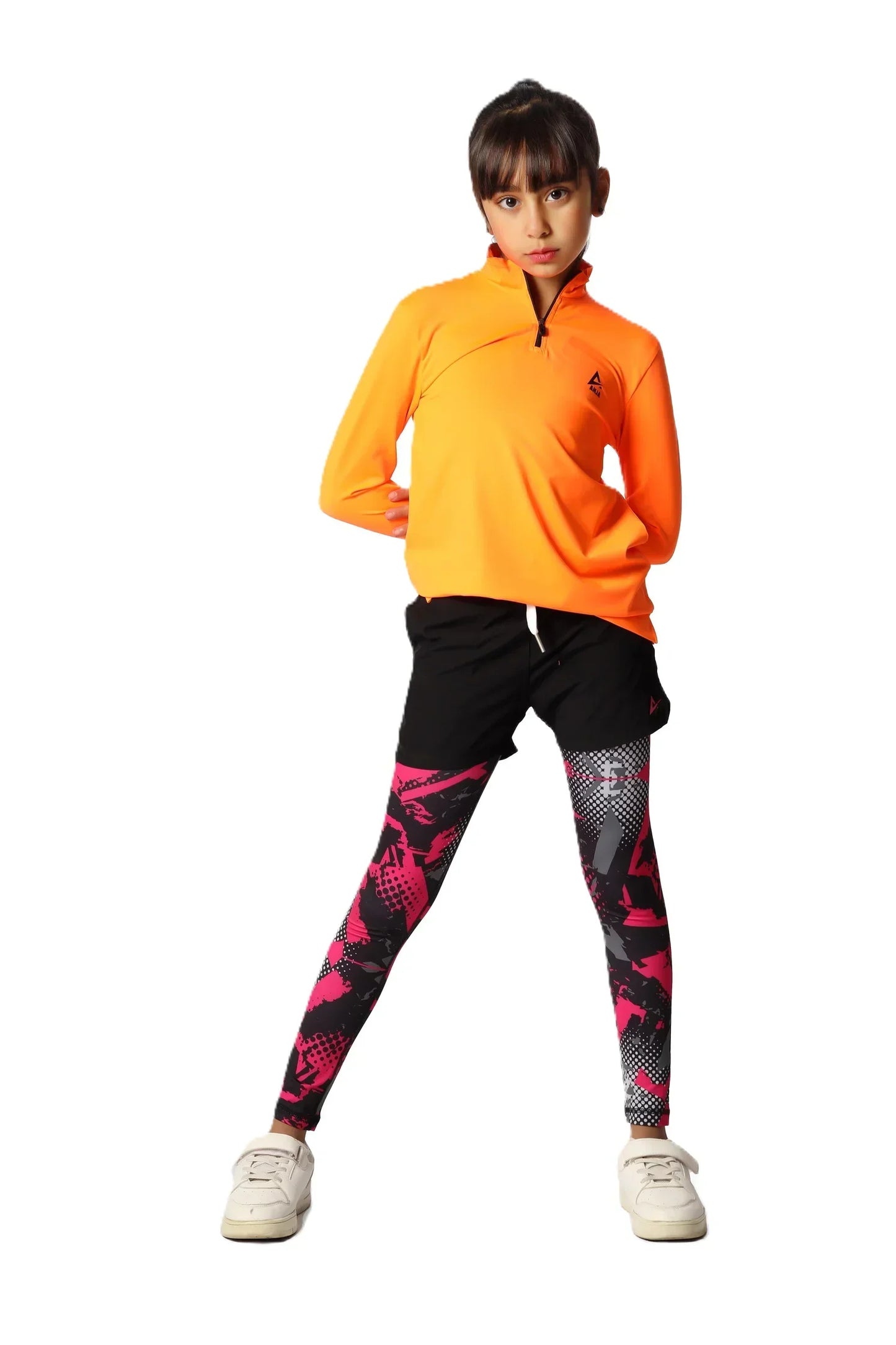 Person wearing an orange jacket and black leggings with pink patterns on a white background