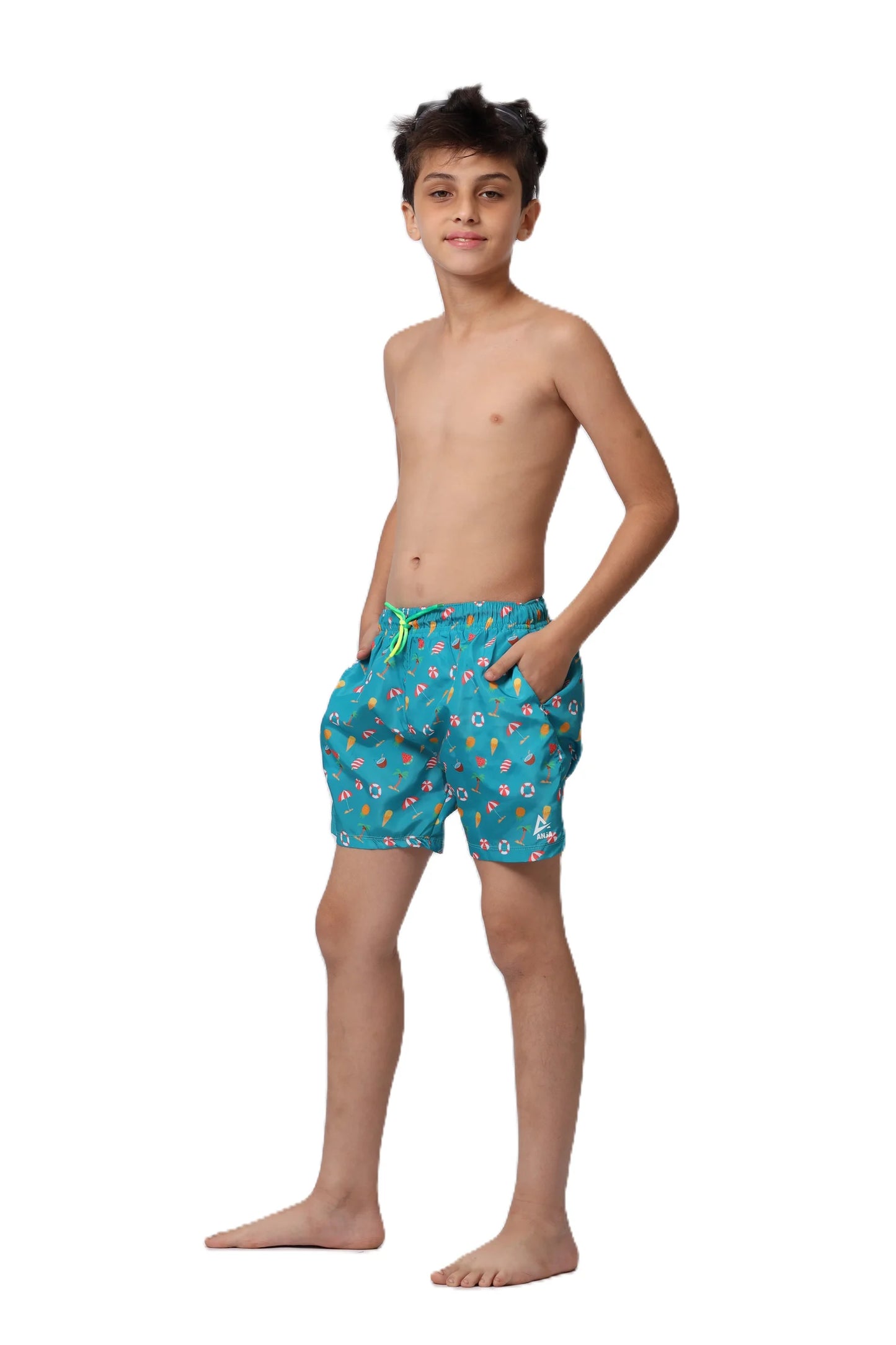 Young boy wearing blue swim shorts with a floral pattern on a white background