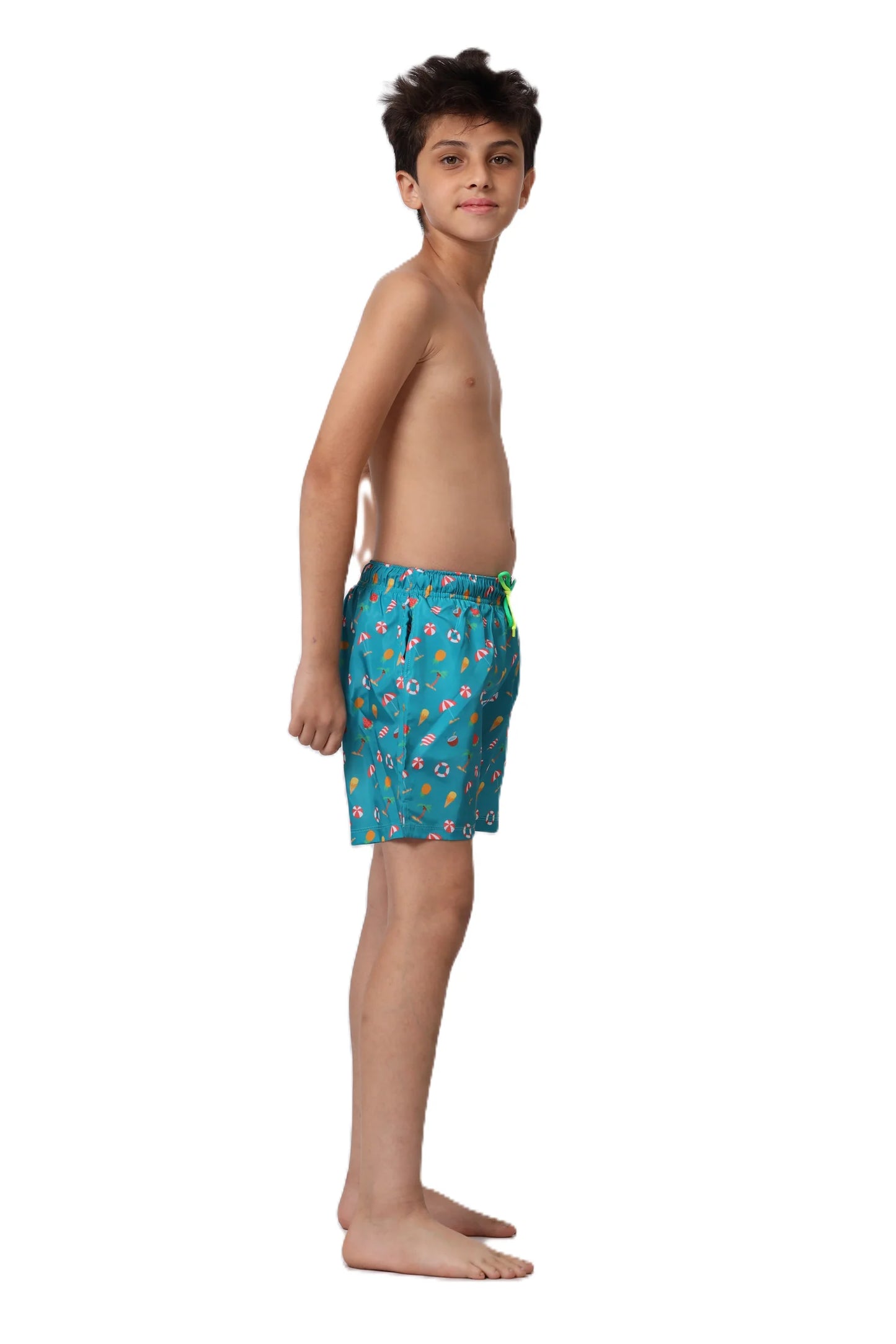 Young boy wearing colorful swim shorts on a white background