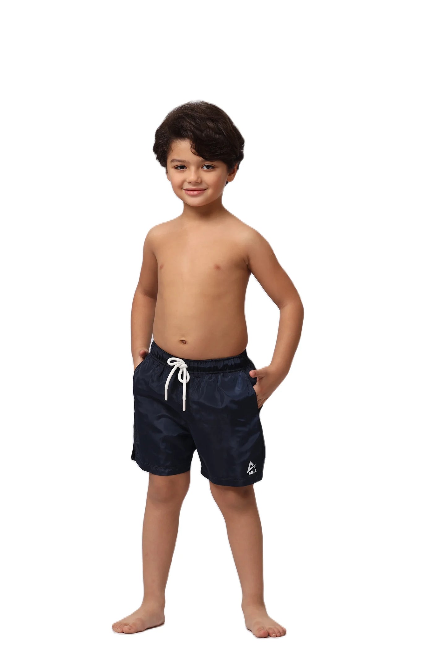 Young boy wearing navy swim shorts on a white background
