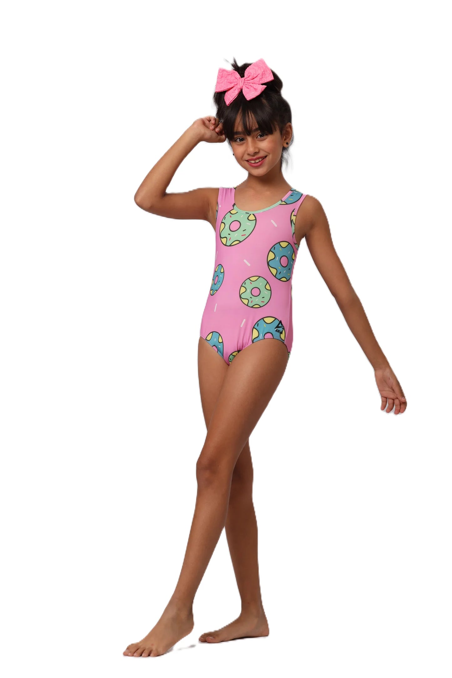 Young girl wearing a pink swimsuit with donut pattern on a white background