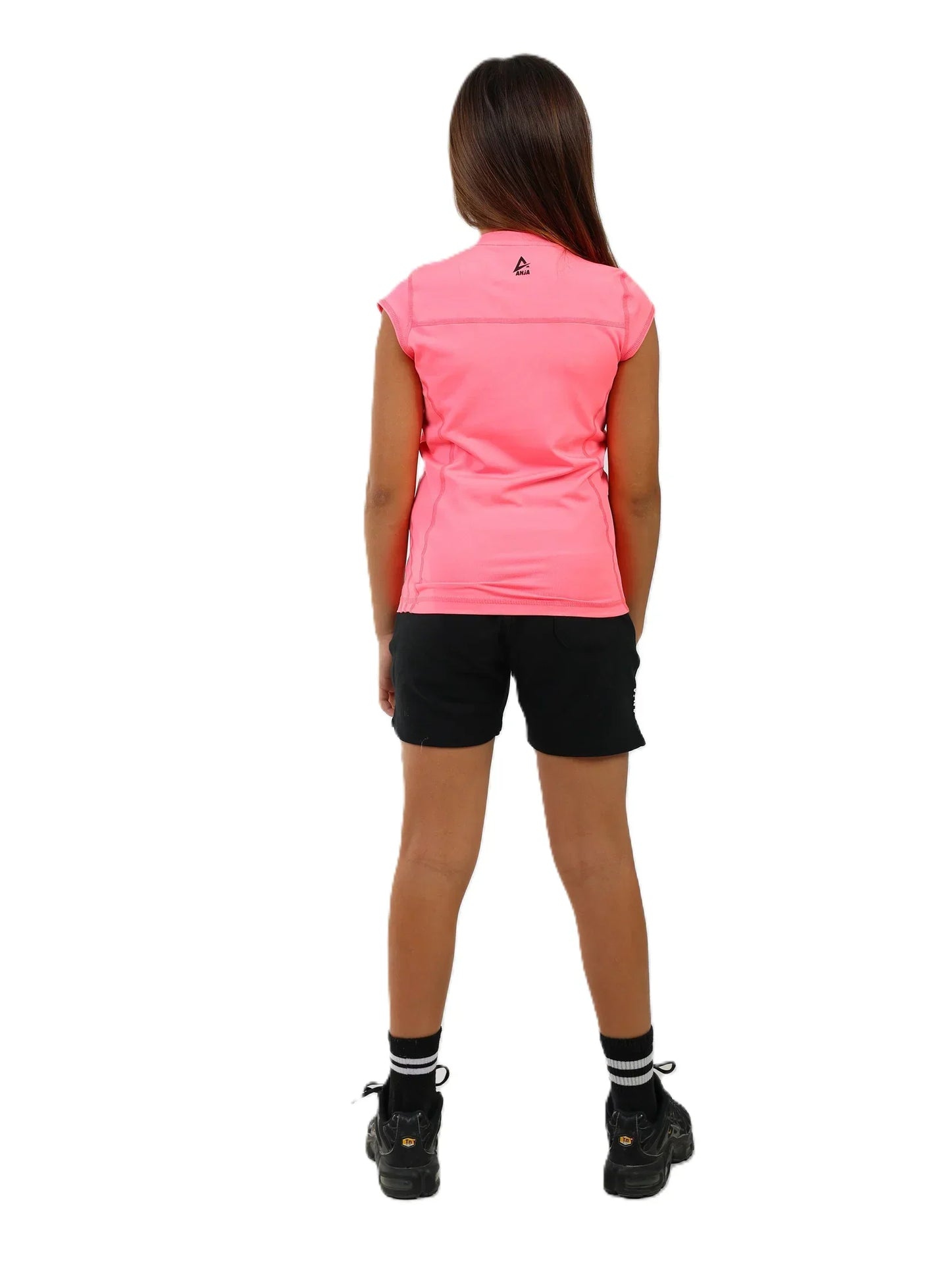 Person wearing a pink sleeveless top and black shorts on a white background