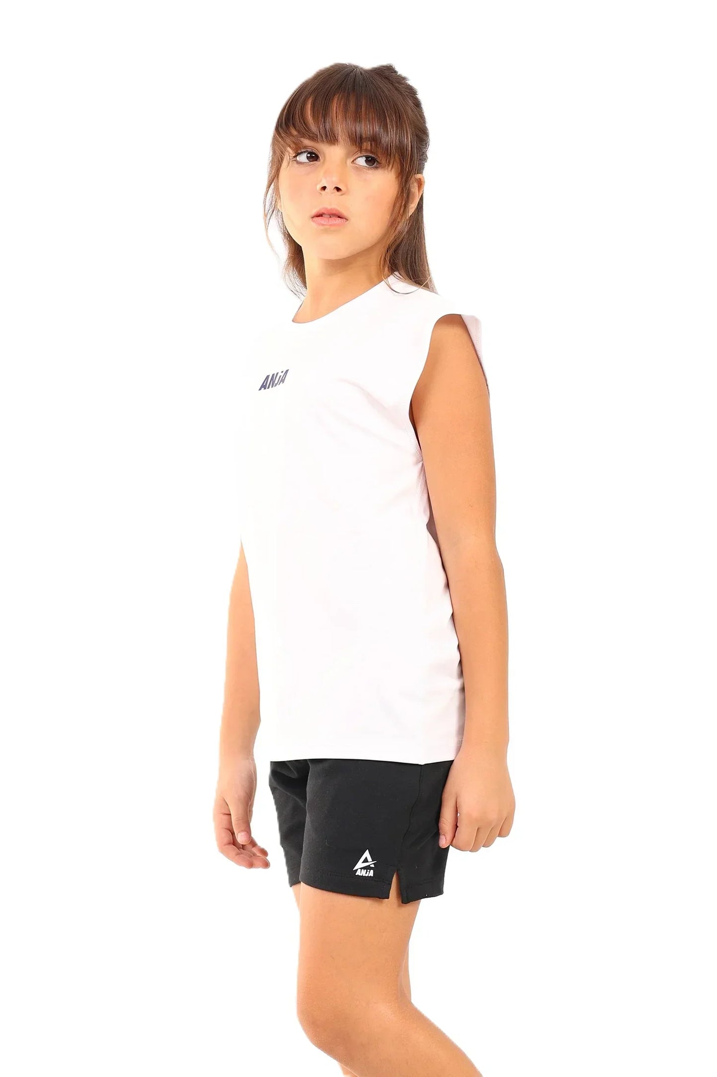 Young girl wearing a white sleeveless shirt and black shorts with a brand logo on a white background