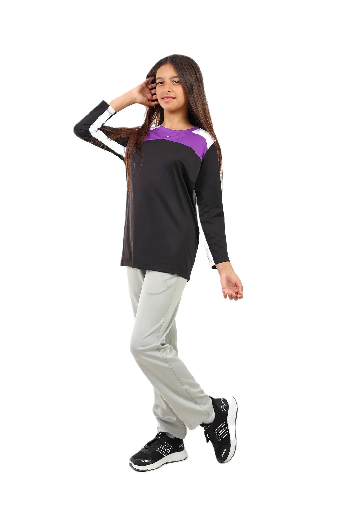 Woman wearing a black and purple top with gray pants on a white background