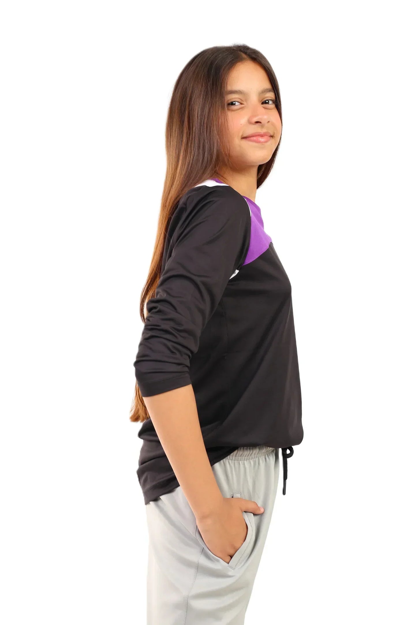 Person wearing a black and purple long-sleeve shirt with gray pants on a white background