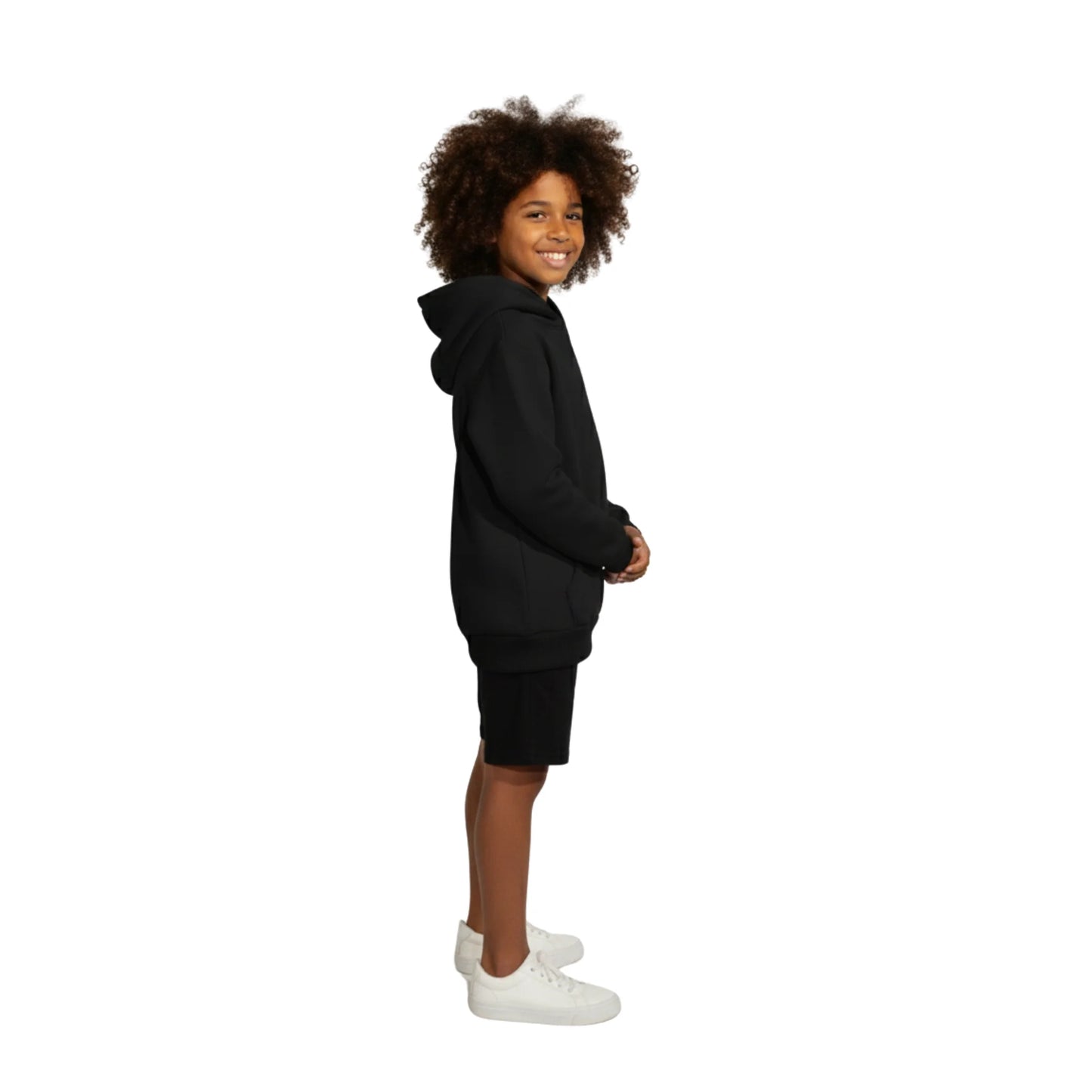 Child wearing a black hoodie and shorts set on a white background