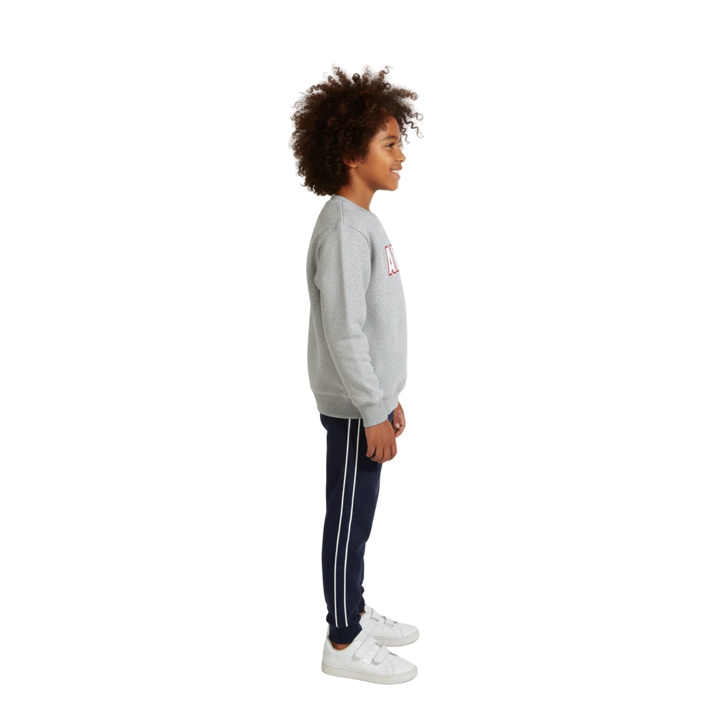 Child wearing a gray sweatshirt and navy tracksuit with white stripes on a white background