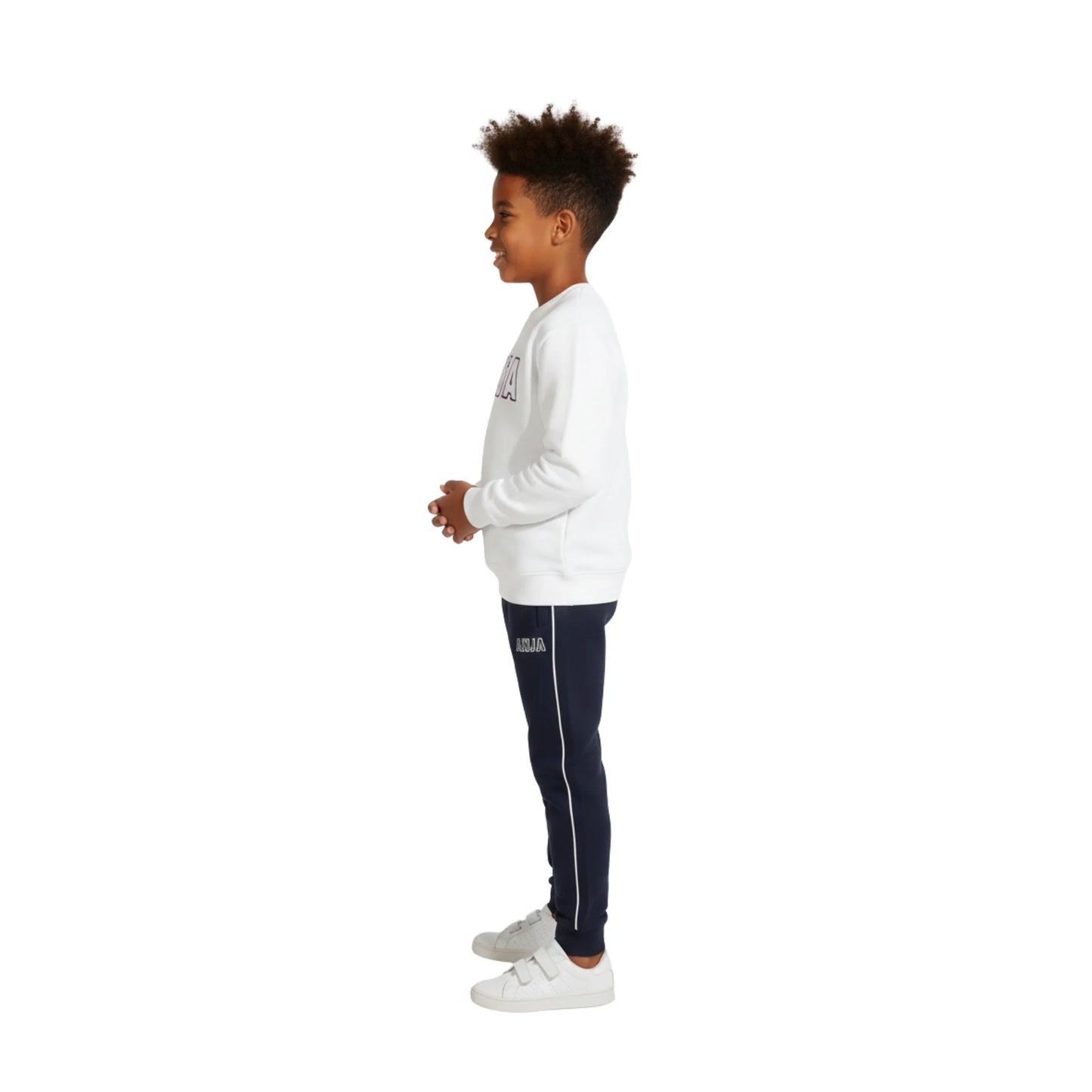 Child wearing a white sweatshirt and navy tracksuit pants on a white background