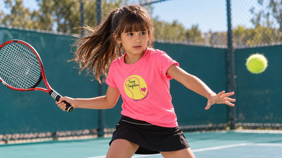 Girl in a pink ANJA tennis tee and black skirt on court